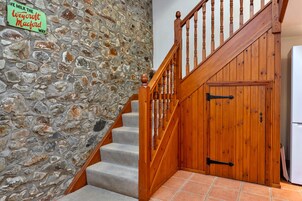 Una escalera con un muro de piedra y una puerta de madera.