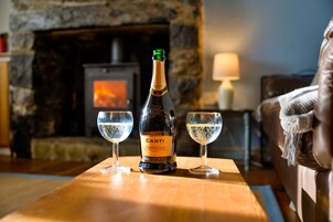 A bottle of Cantina Prosecco DOC on a wooden table with two glasses of wine.