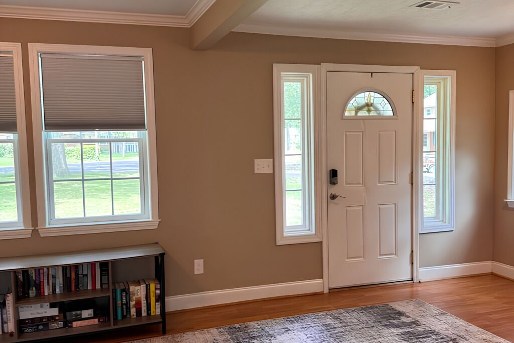 A room with a white door, a bookshelf, and a patterned rug.