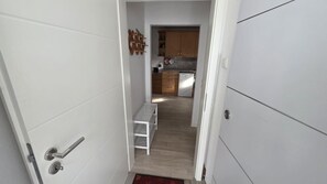 A narrow hallway leading to a kitchen with wooden cabinets and a stainless steel refrigerator. - NEW! Vacation Rental on Schanzenbach (Hartha)
