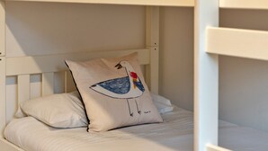 A bunk bed with a pillow featuring a bird illustration. - Kingsand Coastal Retreat for 6 (Bude)