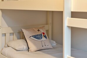 A bunk bed with a pillow featuring a bird illustration. - Kingsand Coastal Retreat for 6 (Bude)