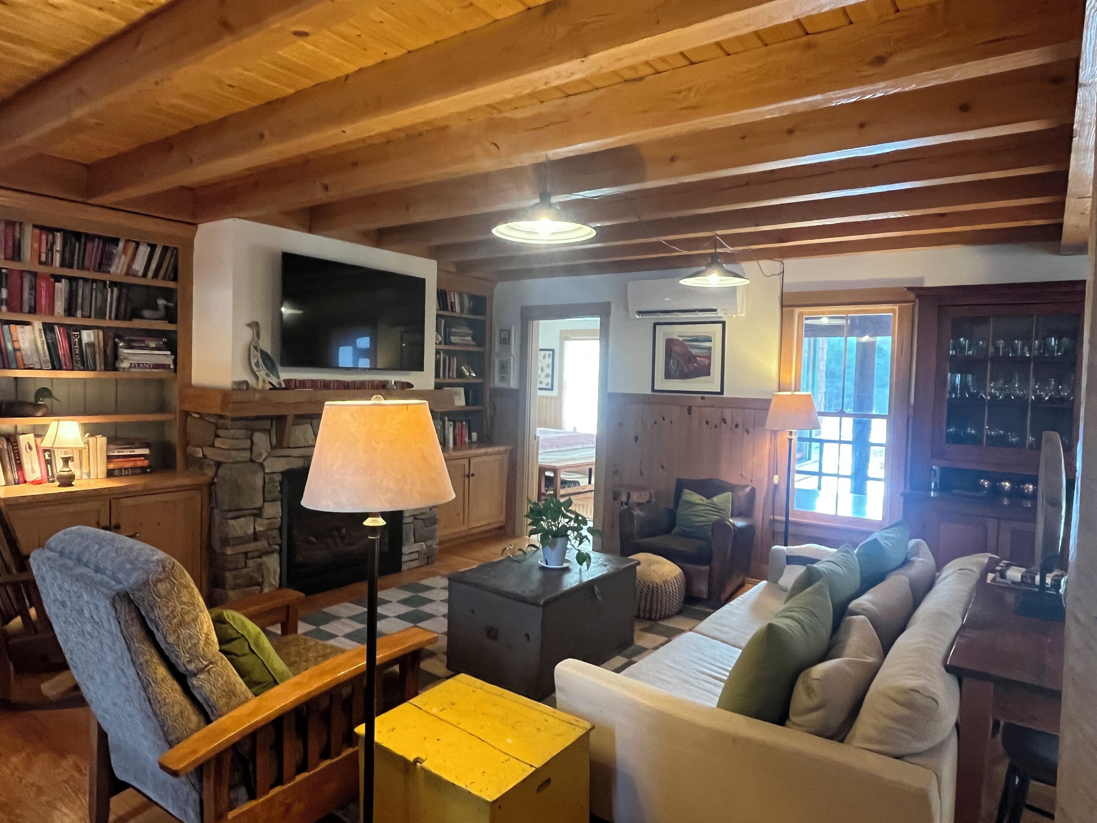 A cozy living room with a fireplace, a television, and a bookshelf.