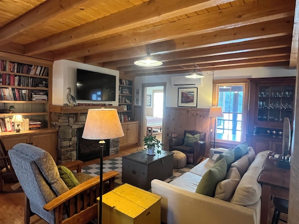 Una sala de estar acogedora con chimenea, televisor y estantería.
