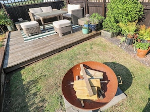 A wooden deck with outdoor furniture, a fire pit, and potted plants. - St.twynells Farm (Pembroke)
