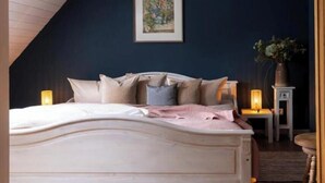 Un dormitorio con cama, mesitas de noche y un velador.