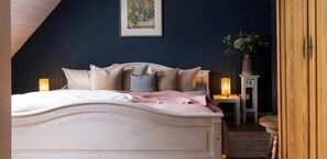 Un dormitorio con cama, mesitas de noche y un velador.