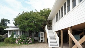 Une maison à deux étages avec un escalier en bois menant à un porche.