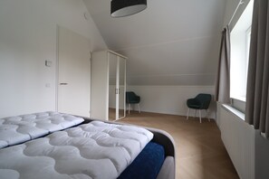 A bedroom with two beds, a wardrobe, a desk, two chairs, and a window with curtains. - Private Bungalow With Jetty for 6 (Makkum)