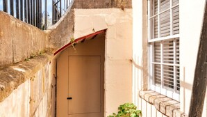 A narrow alleyway with a door, a small plant, and a window with shutters. - Peaceful Dorset Cottage for 4 (Bath)