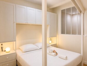 A hotel room with a bed, bedside tables, a lamp, and a window. - Appartement au Panier • Clim • 4 pers (Marseille)