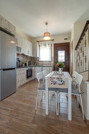 Eine moderne Küche mit Essbereich, Holzboden und einer Pendelleuchte.