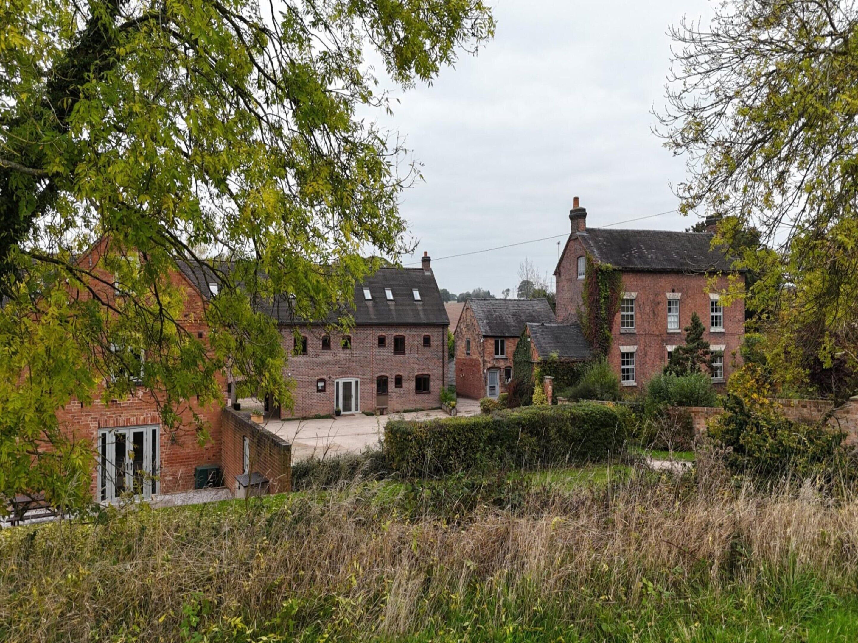 Une rangée de maisons traditionnelles en briques, dotées de nombreuses fenêtres et d’une cour centrale.