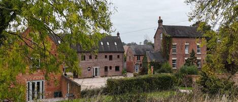 Une rangée de maisons traditionnelles en briques, dotées de nombreuses fenêtres et d’une cour centrale.
