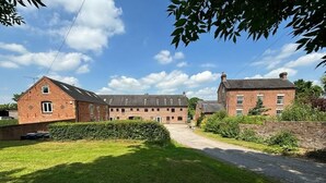 A large brick building with multiple windows and a central courtyard. - Scenic Snowdonia Coastal Cabin (Ashbourne)