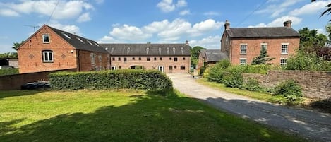 A large brick building with multiple windows and a central courtyard.