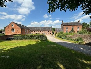 A large brick building with multiple windows and a central courtyard. - Scenic Snowdonia Coastal Cabin (Ashbourne)