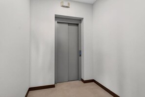 A closed elevator door in a hallway with a light fixture above it. - Las Catalinas Escape, Ocean View & Plunge Pool (Las Catalinas)