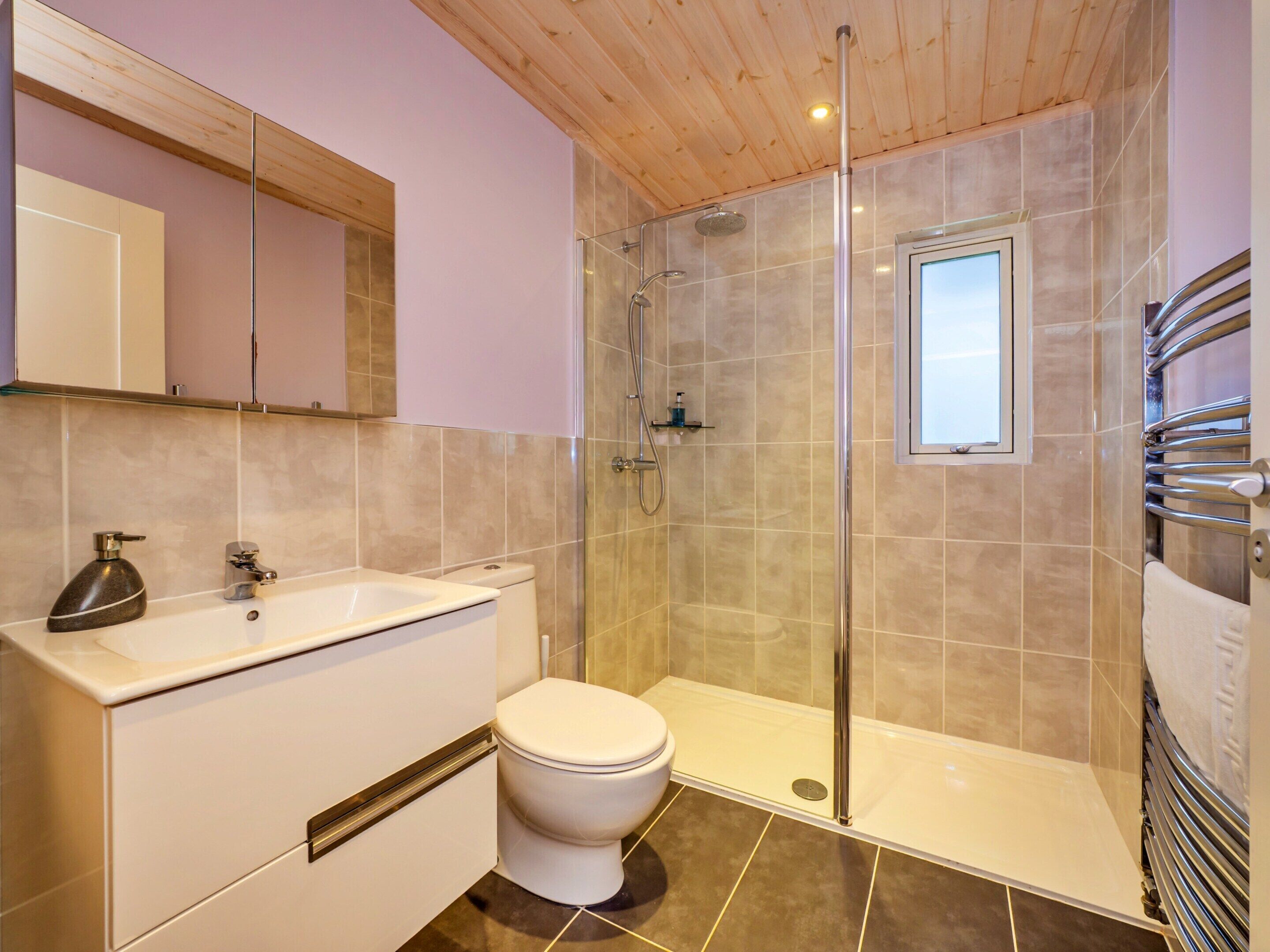 A bathroom with a shower, toilet, and sink.