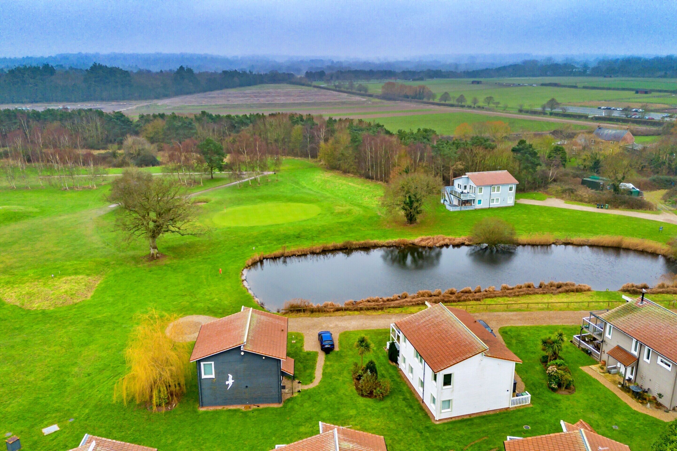 A residential area with houses, a pond, and a golf course.