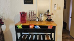 A coffee station with a sign reading 'CAFE GOURMET,' a coffee machine, a coffee grinder, and a bag of coffee pods. - Red Rock Rendezvous - Steps Away From Uptown Sedona Shops & Dining (Sedona)