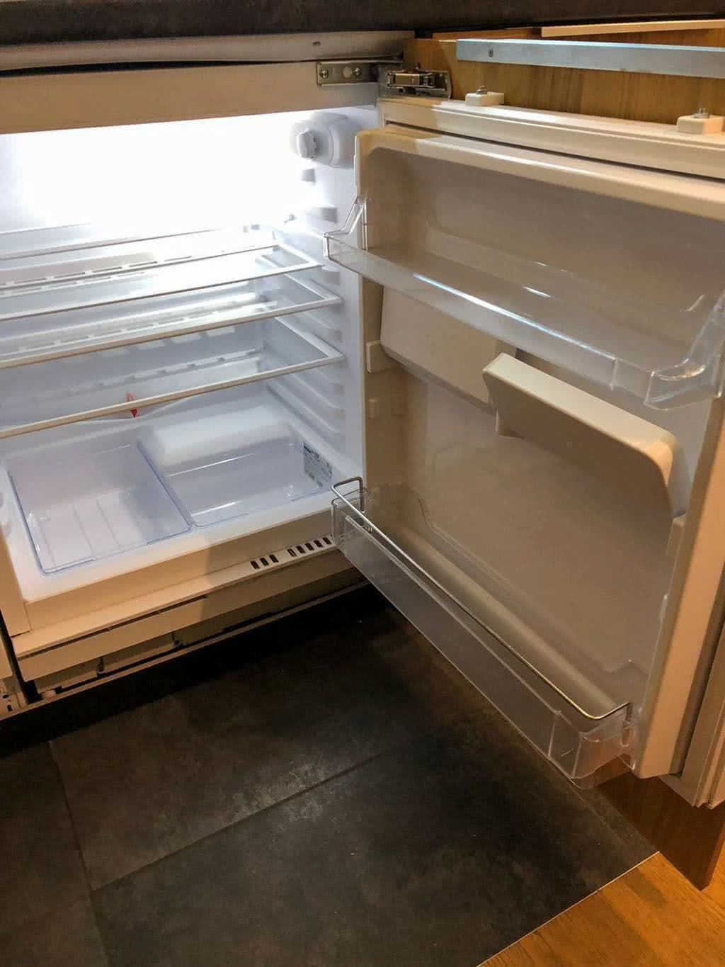 An open refrigerator with multiple shelves and a freezer compartment.