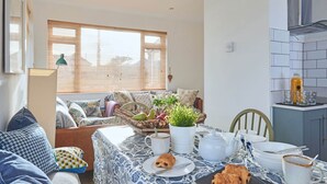 Un coin repas accueillant, avec une table dressée pour deux personnes, où l’on propose une variété de plats et une théière.