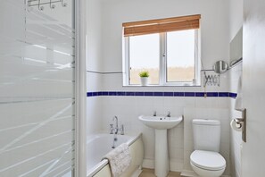 Un bagno con vasca, lavandino e WC.