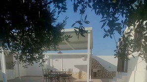 Un espace patio avec un chemin de pierre menant à un coin salon équipé de chaises et d’une table.