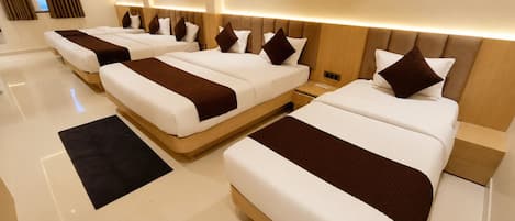 A hotel room with a large bed, a smaller bed, and a desk with a chair.