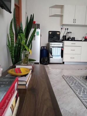 A kitchen with a refrigerator, a coffee maker, a sink, and cabinets. - Serene Palace (Nairobi)