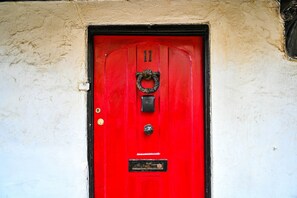 Eine rote Tür mit Türklinke, Schlüsselloch und Briefschlitz.
