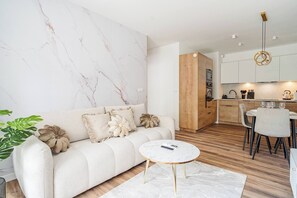 Ein modernes Wohnzimmer mit einer Couch, einem Couchtisch und einem Essbereich mit Stühlen.