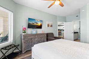 A bedroom with a bed, dresser, chair, and a ceiling fan. - Summerwind West 804 (Navarre)