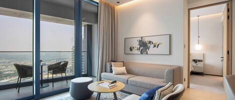 Une chambre d’hôtel moderne avec un balcon, un canapé, une table basse et un tableau.