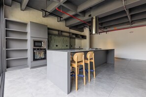 Eine moderne Küche mit einer zentralen Kochinsel, Backofen und Barhocker.