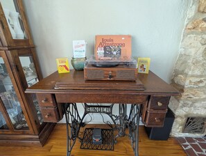 A wooden desk with a vintage radio, a book titled 'Louis Armstrong,' and two postcards. - Charming 2-bedroom 1935 bungalow in downtown New Port Richey (New Port Richey)