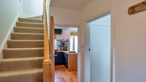 A staircase leading to a kitchen area with wooden flooring and a door leading to another room. - Peaceful Lochside Retreat for 4 (Bude)