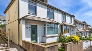 A two-story residential building with a front door, windows, and a small garden area. - Peaceful Lochside Retreat for 4 (Bude)