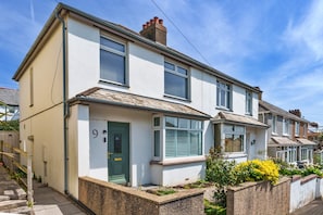 A two-story residential building with a front door, windows, and a small garden area. - Peaceful Lochside Retreat for 4 (Bude)