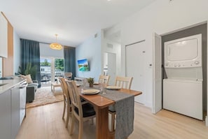 A modern kitchen with a dining area, wooden chairs, and a built-in oven.
