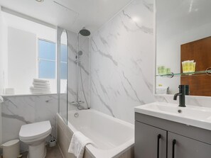 Ein modernes Badezimmer mit Badewanne, Toilette und Dusche.