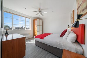 Ein modernes Schlafzimmer mit Bett, Nachttisch und Schreibtisch.