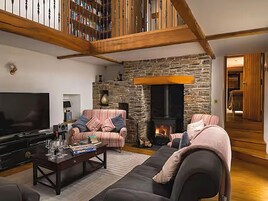 Una sala de estar acogedora con chimenea de piedra, televisor de pantalla plana y asientos cómodos.