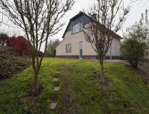 A two-story house with a sloped roof, a front door, and a small front yard with a pathway leading to the door. - Beach Villa With Sauna in Makkum (Makkum)