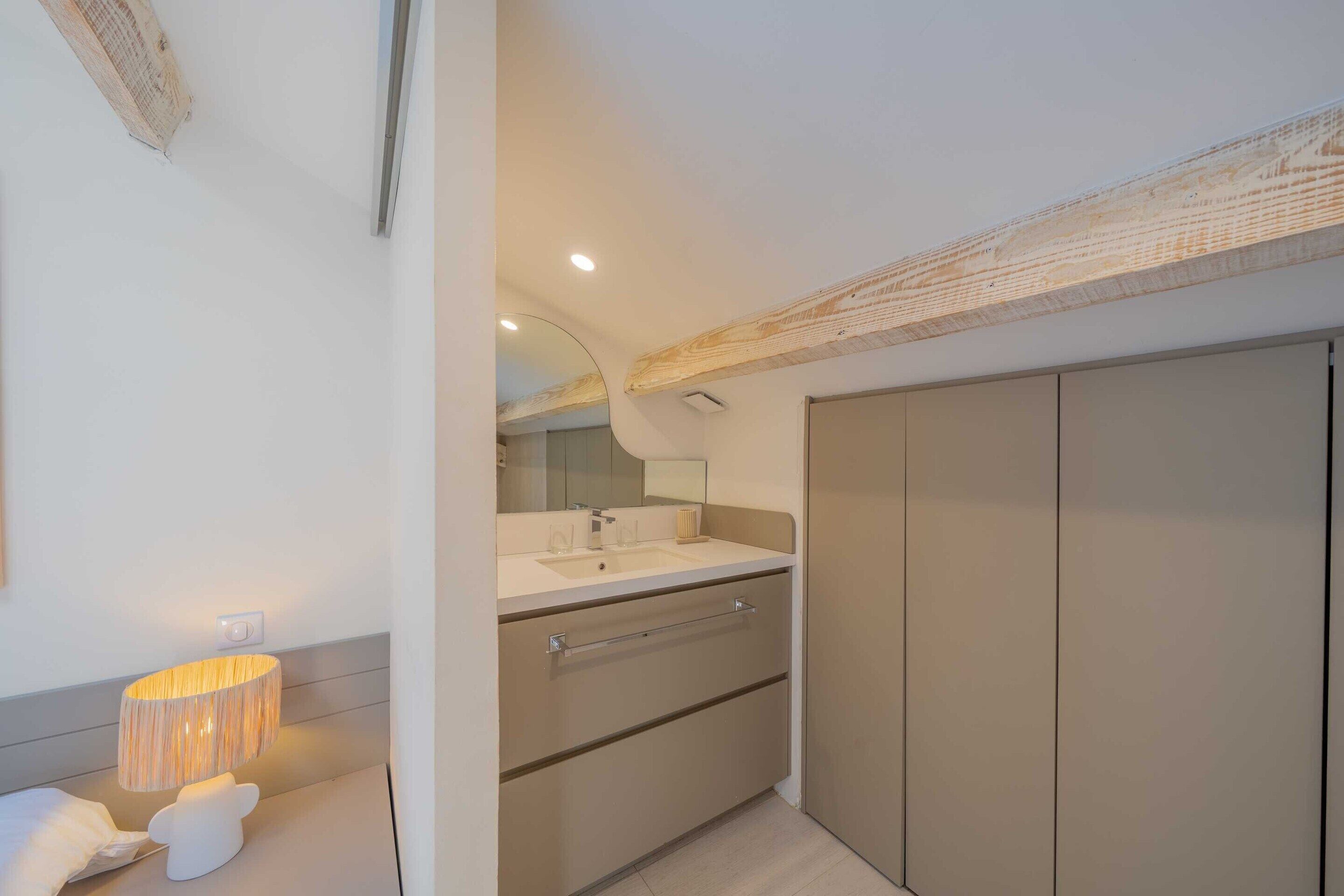 Un baño moderno con tocador, espejo y un mueble grande.