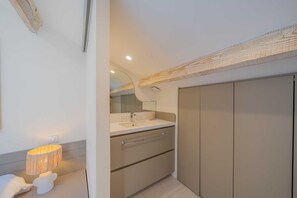 Un baño moderno con tocador, espejo y un mueble grande.