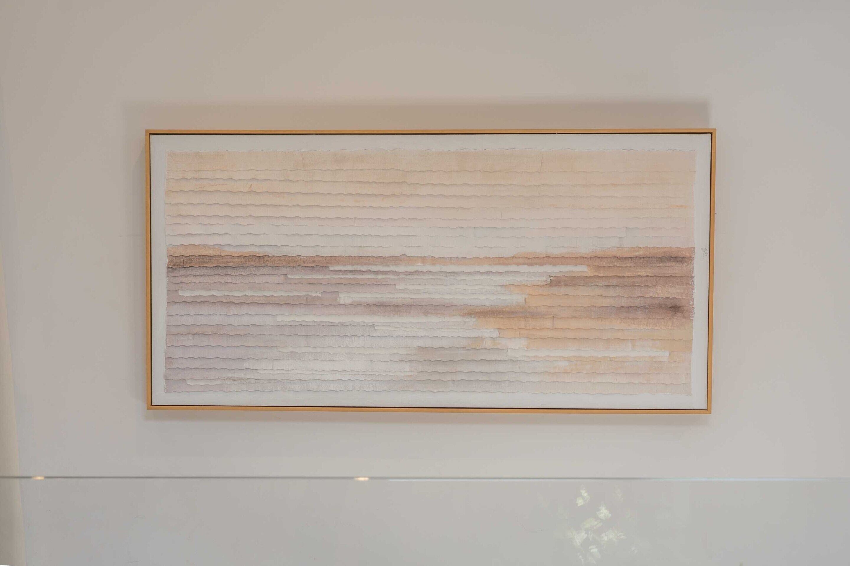 A framed abstract painting on a wall.