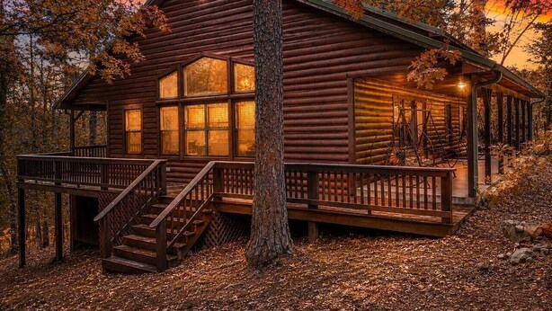 A log cabin with a wooden deck, a staircase, and a porch. - Arrowhead Ridge 3 bedroom 3 bathroom, hot tub, wrap around deck. (Broken Bow)