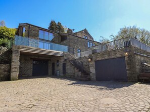 A two-story stone building with a garage, a balcony, and a staircase leading to the upper floor. - Rocks Cottage (Halifax)